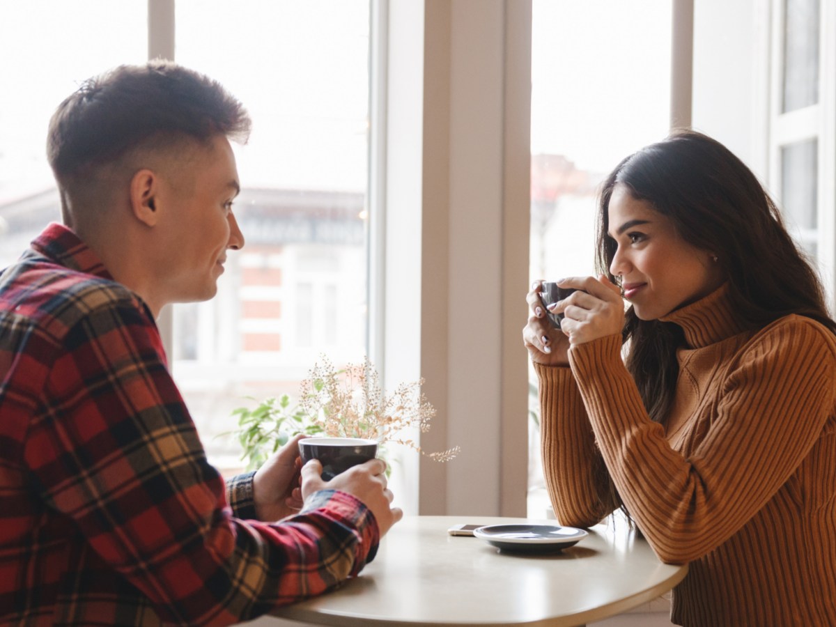 Mann und Frau in einem Café auf einem Date, die sich anlächeln