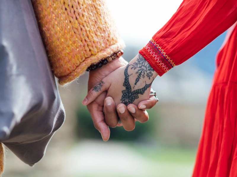 Zwei Personen halten H&auml;ndchen, eine davon hat ein Boho Tattoo auf dem Handr&uuml;cken