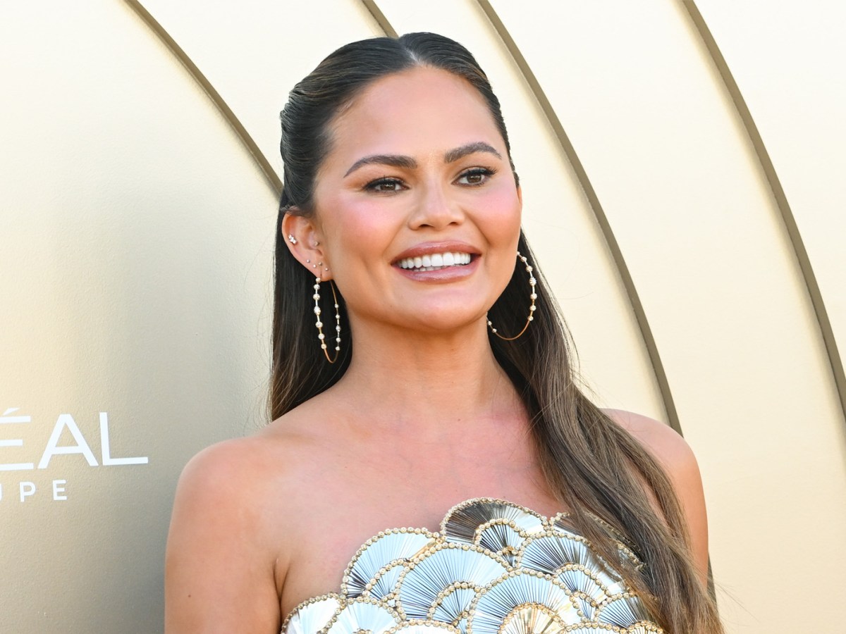 Chrissy Teigen mit halbhoch gesteckten Haaren, die ihrer runden Gesichtsform schmeicheln.