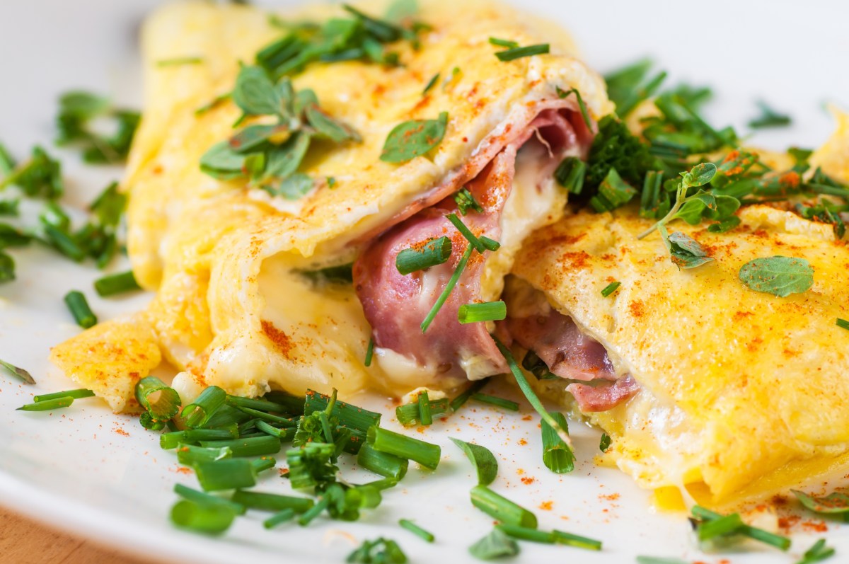 Low Carb Frühstück mit Omelette mit Käse und Schinken darauf Kräuter