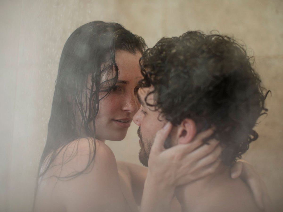 Paar küsst sich unter der Dusche