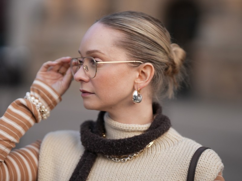 Streetstyle mit Pilotenbrille zu Strickpullover und Schal.
