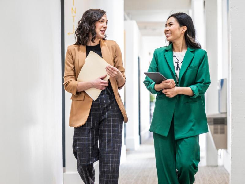 Zwei Frauen mit modernen und stylischen Outfits im Büro.