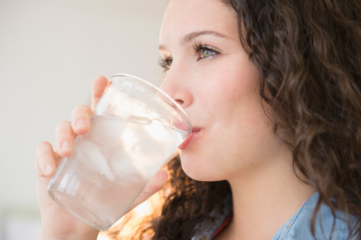 Junge Frau trinkt ein Glas Wasser