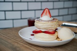 Fluffy Pancakes mit Erdbeeren und Eis auf einem Teller in der Küche