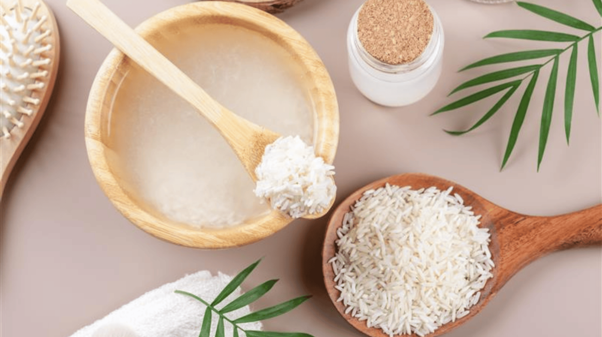 Hausgemachtes kosmetisches Reiswasser mit Zutaten und Beauty-Set auf beigefarbenem Hintergrund