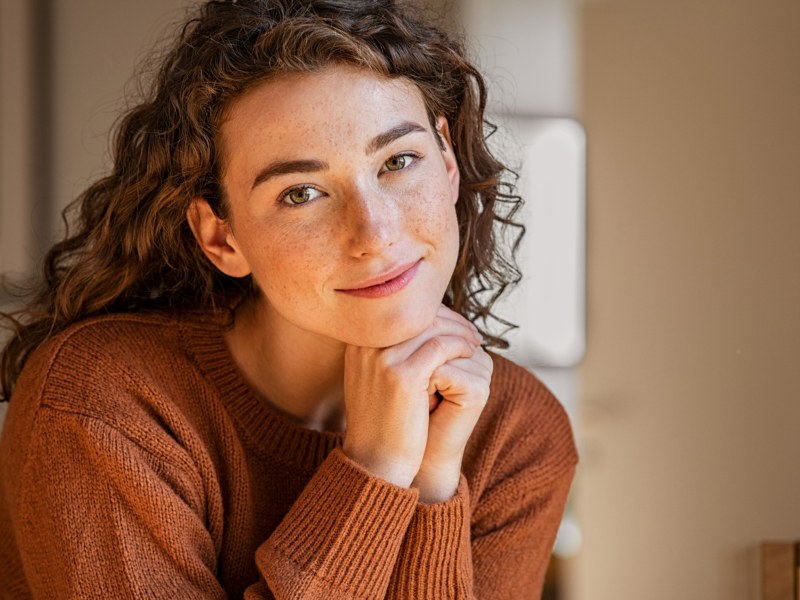 Junge Frau schaut freundlich in die Kamera.