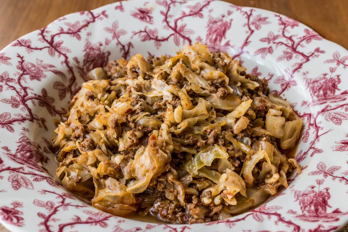 Durchgebratenes Hackfleisch mit Weißkohl auf einem Teller angerichtet.