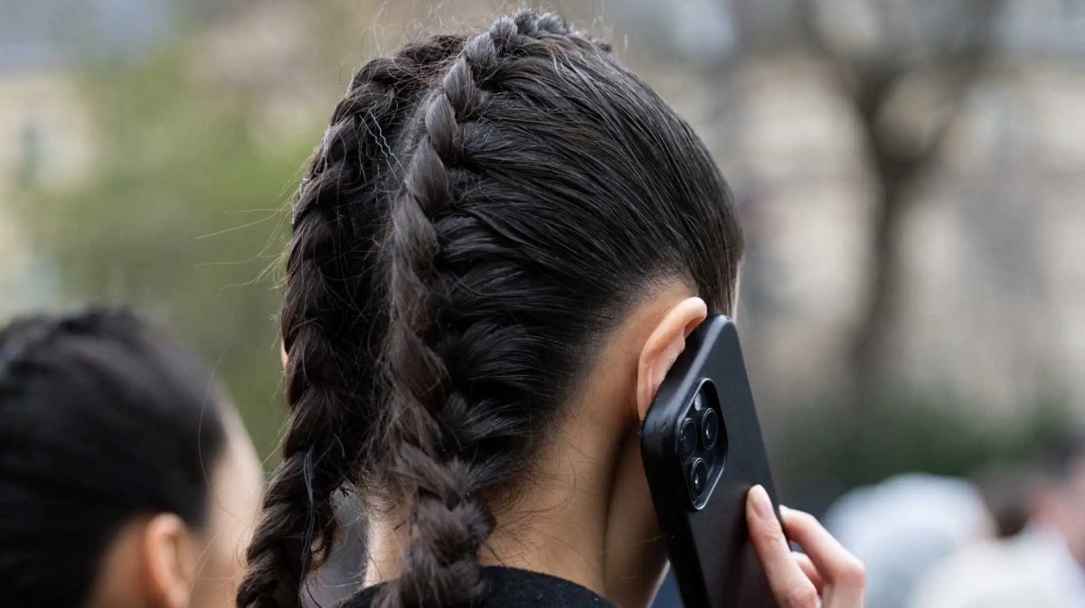 Frau mit schwarzen Haaren hat zwei geflochtene Dutch Braids