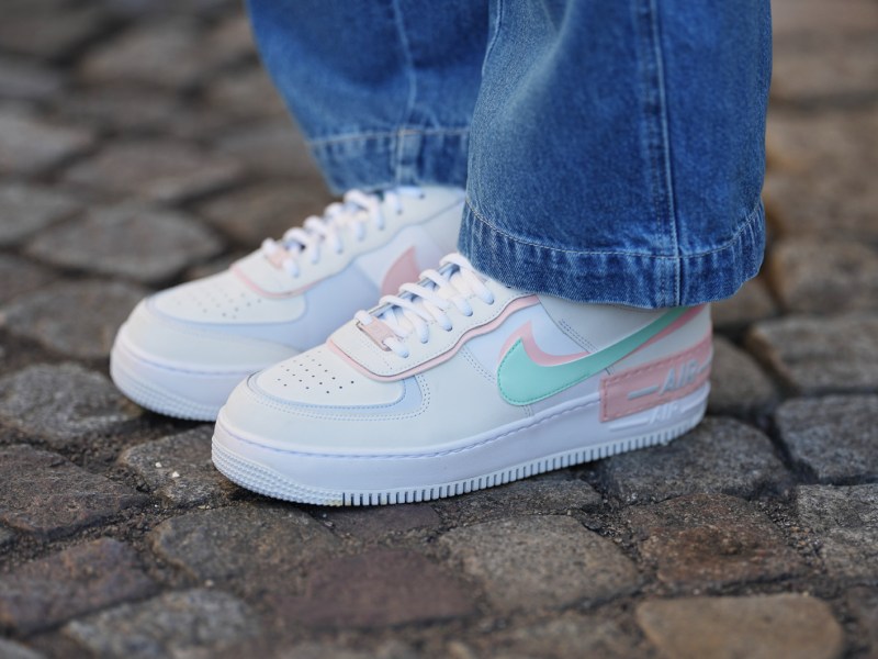Wei&szlig;er Sneaker von Nike mit farbigen Details zur blauen Jeans.