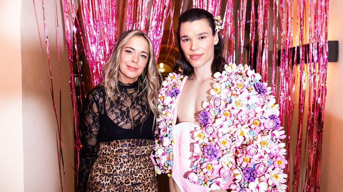 Marina Hoermanseder in schwarzer Spitzenbluse und Leo-Rock steht neben Helge Mark der ein mit Lego Botanicals besetztes Outfit trägt.