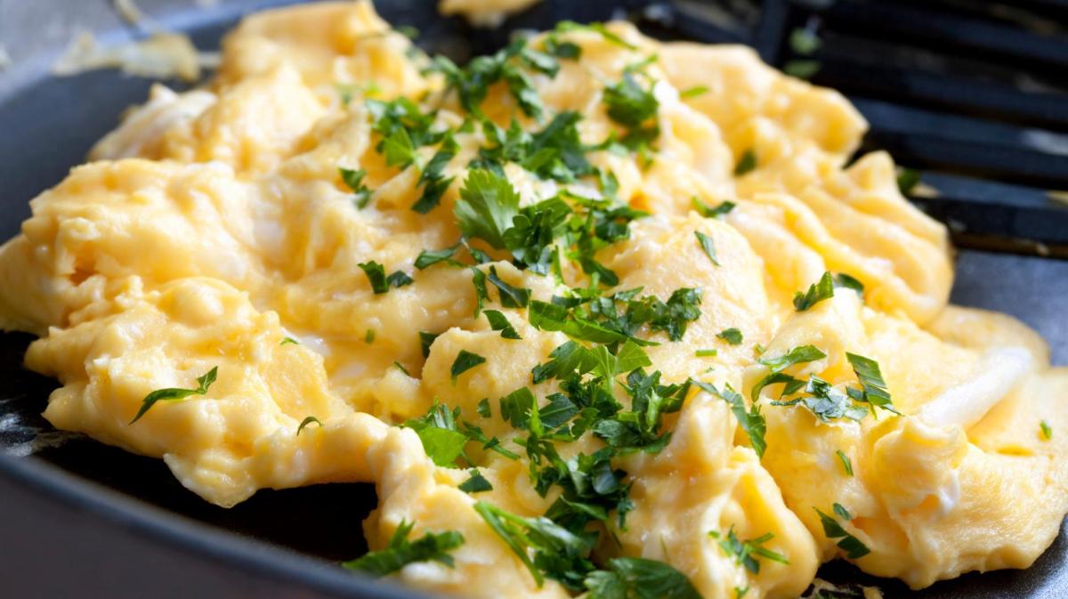 Französisches Rührei mit Petersilie in einer Pfanne.