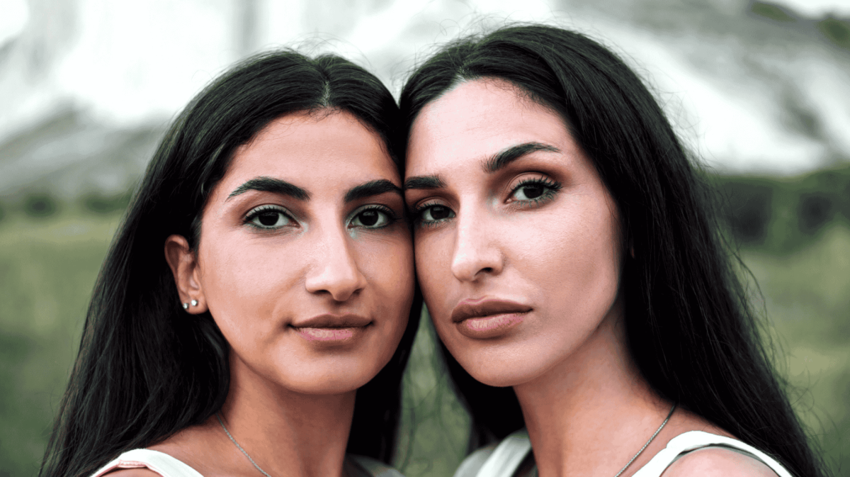 Zwei Frauen stehen Wange an Wange nebeneinander