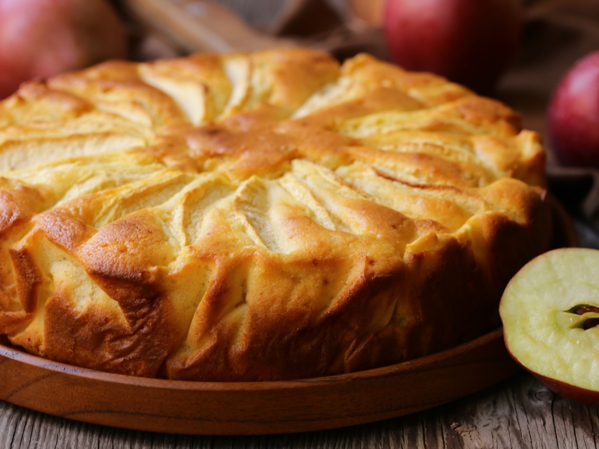 Apfelkuchen auf einem Holzteller.