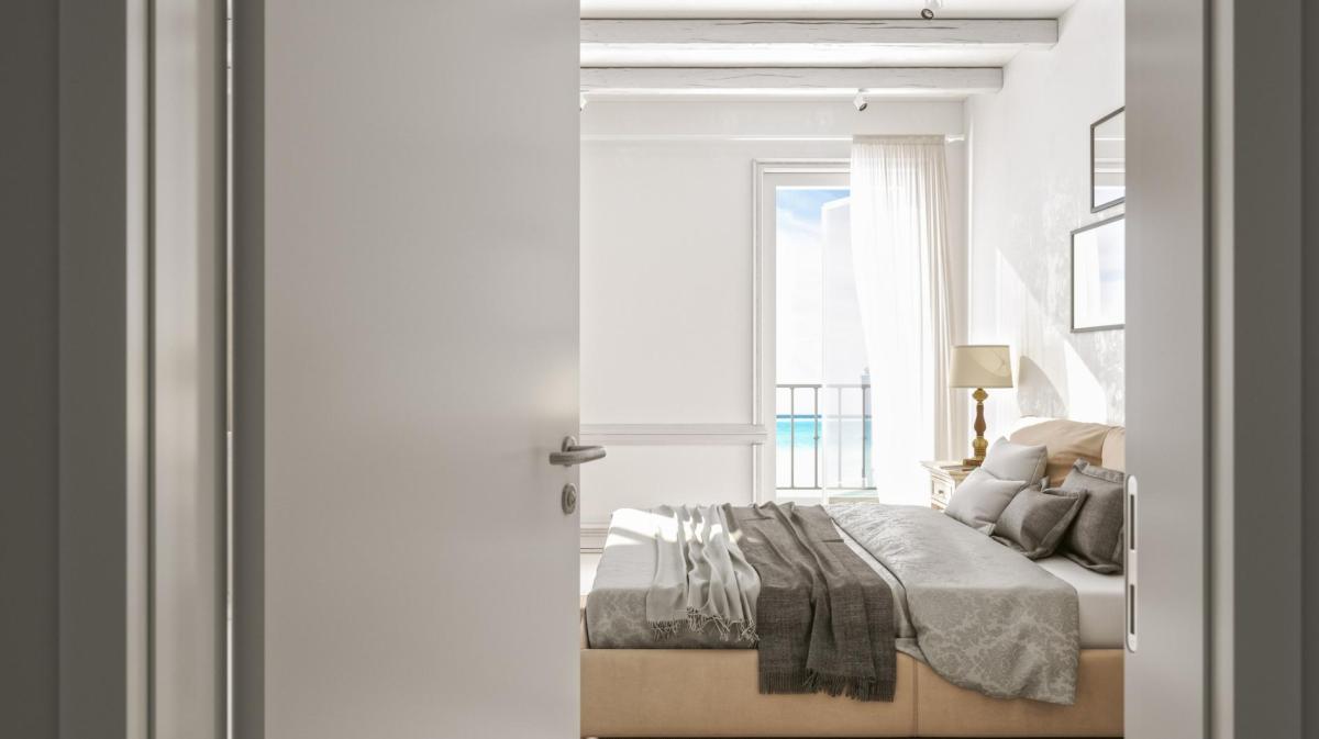 Die Schlafzimmertüre steht offen und dahinter steht ein Doppelbett.