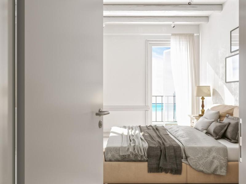 Die Schlafzimmertüre steht offen und dahinter steht ein Doppelbett.