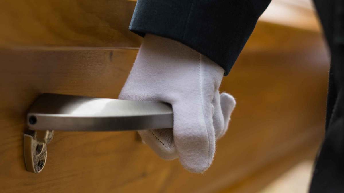 Bestatter trägt einen Sarg,