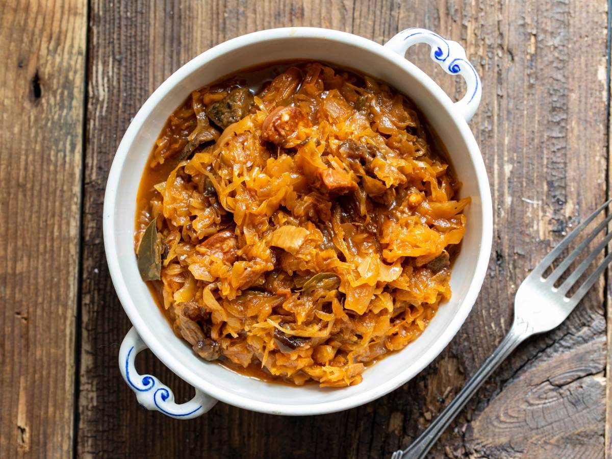 Aufnahme von oben: Schüssel mit einer Portion Bigos, daneben liegt eine Gabel.