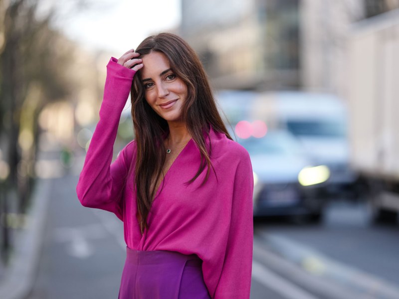 Frau mit pinker Bluse und langen Haaren