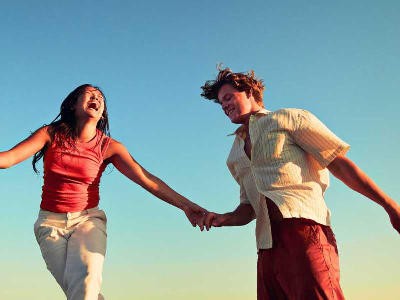 Low Angle View von glücklichen Freunden genießen vor dem klaren blauen Himmel.