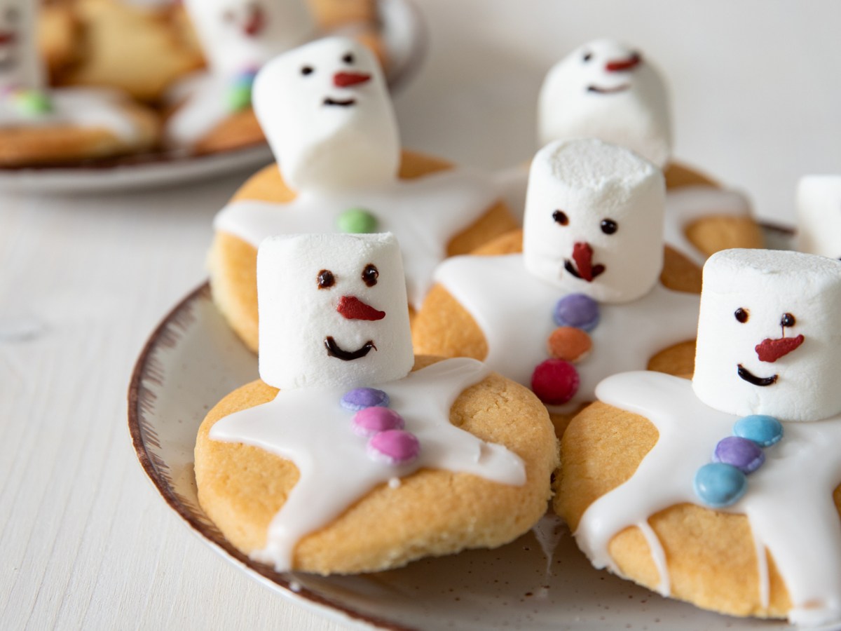 Schneemann Plätzchen mit Marshmallows auf Teller.