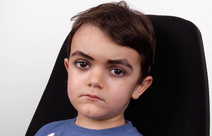 Bild eines Jungen mit betonten und eckig geschminkte AUgenbrauen.