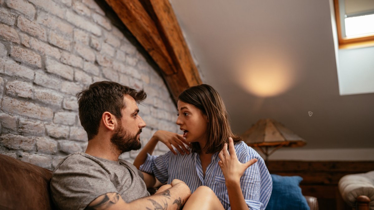 Frau und Mann in einem Zimmer, die miteinander sprechen und gestikulieren