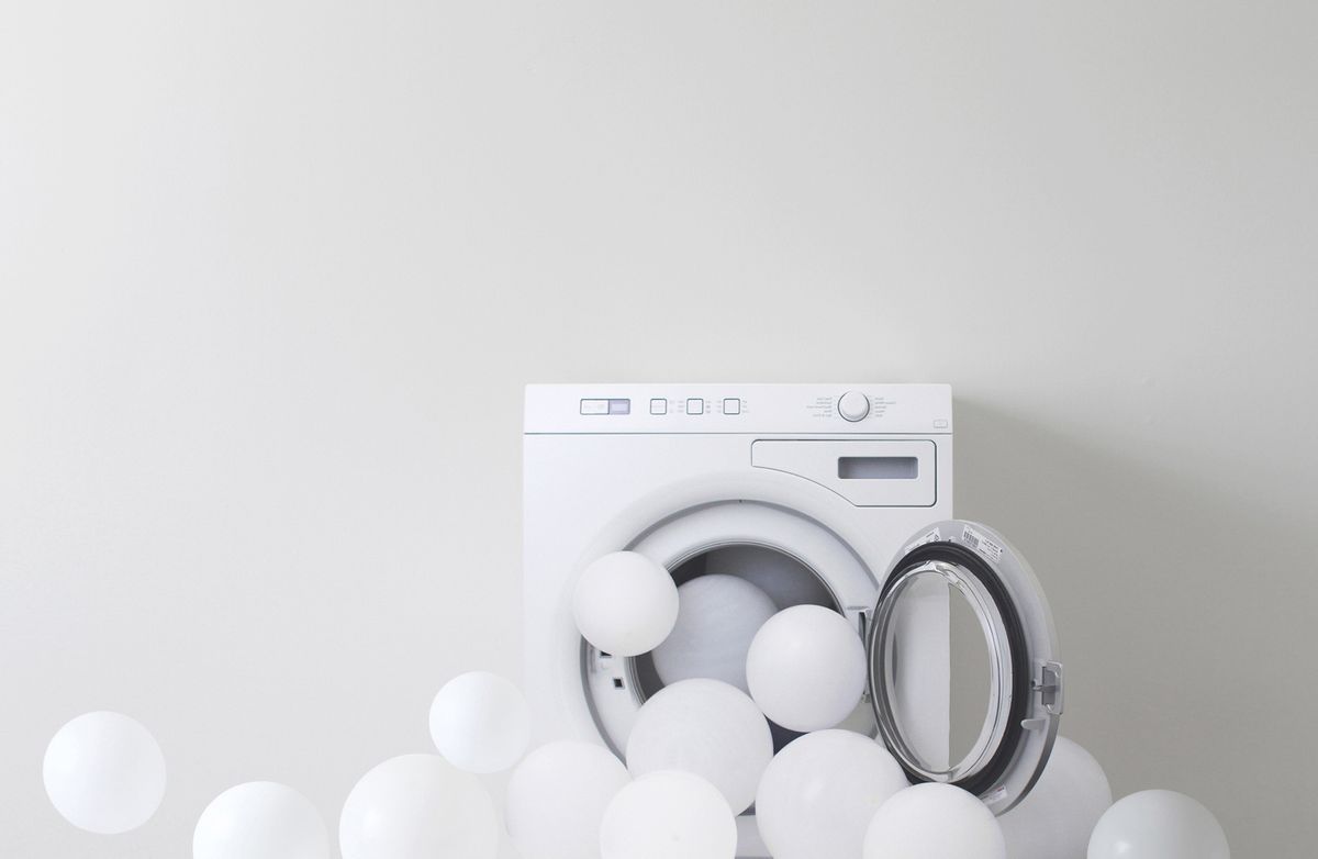 Waschmaschine mit wei&szlig;en Ballons.