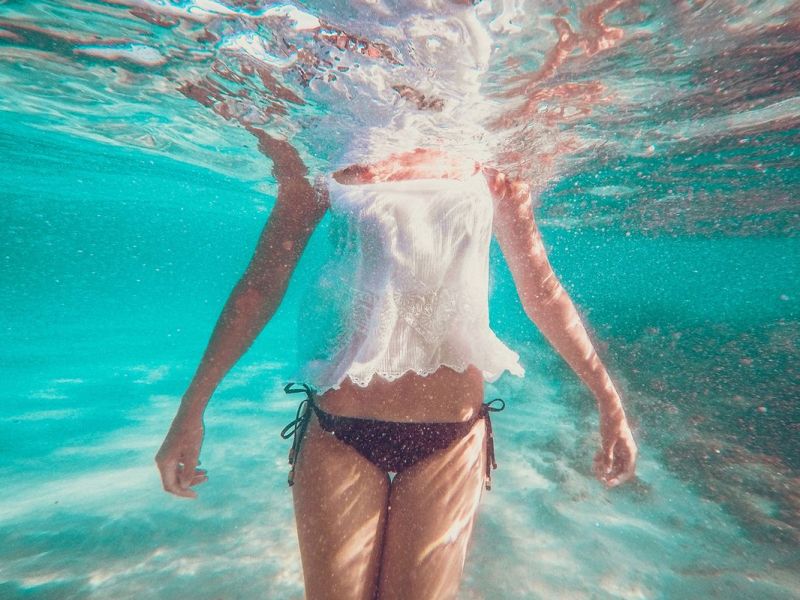 Weibliche Person steht im Wasser, Unterwasseraufnahme