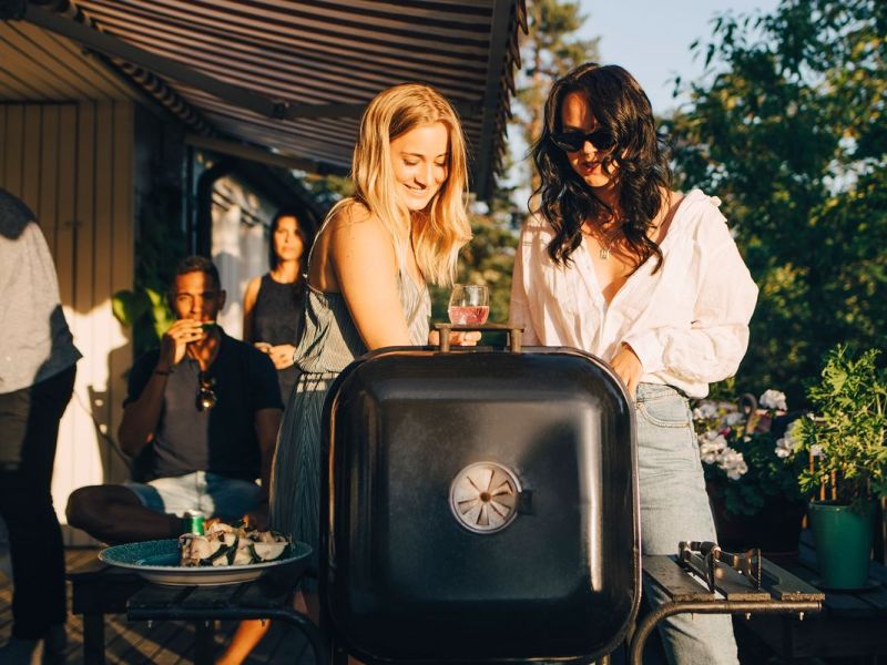 Zwei Frauen am Grill bei einer Garten-Party.