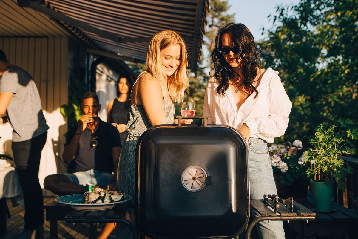 Zwei Frauen am Grill bei einer Garten-Party.