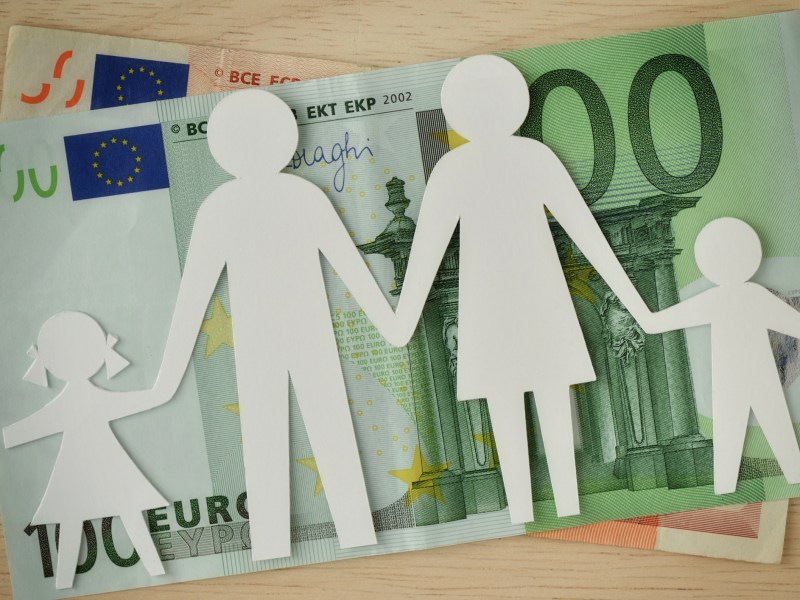 Kindererziehung auf Rente anrechnen lassen: Papierfamilie vor 100 Euro Schein