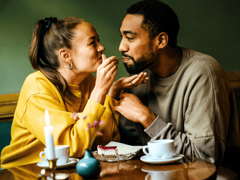 Pärchen isst Kuchen, Frau füttert ihren Freund.