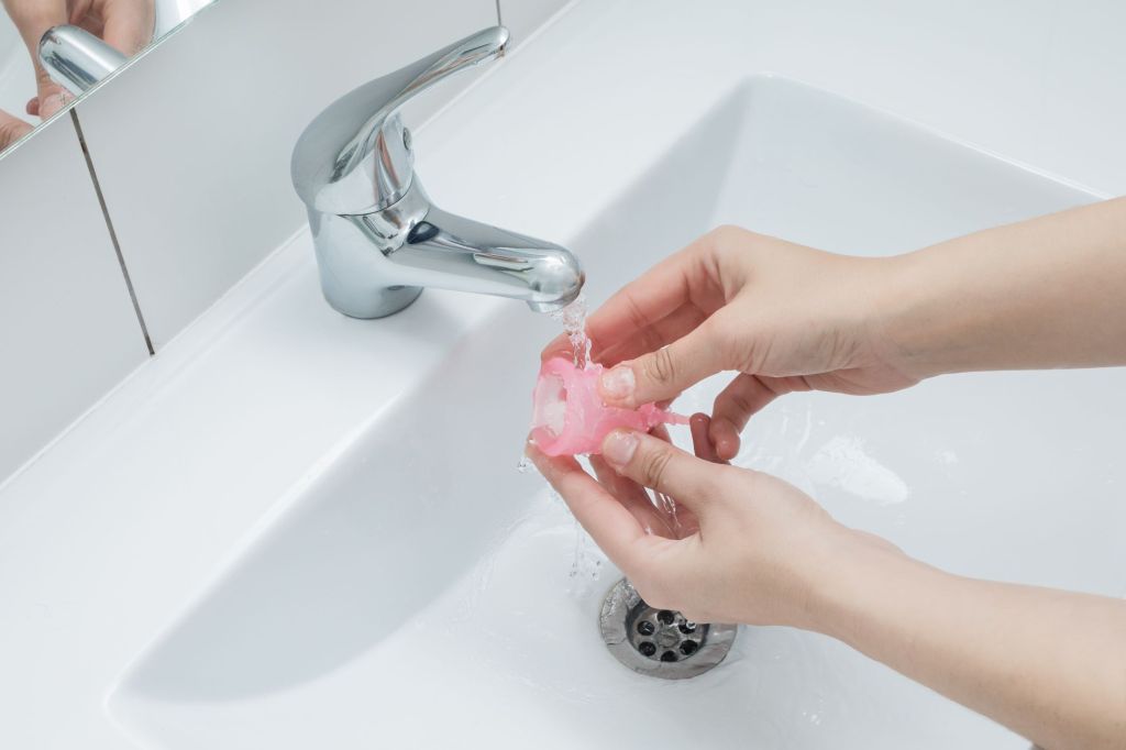 Menstruationscup mit Wasser auswaschen