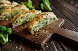 Brokkoli-Bl&auml;tterteig-Strudel auf einem Holzbrett.