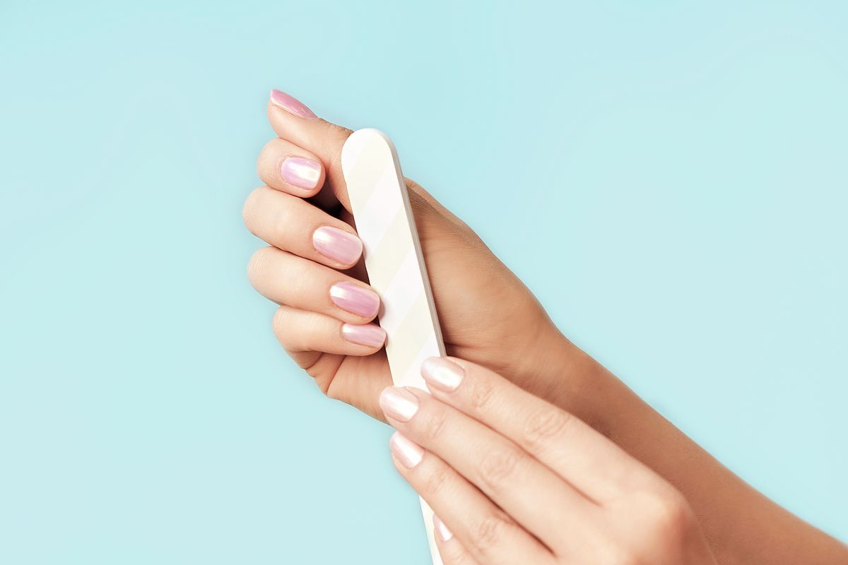 Fingernägel werden mit einer Nagelfeile in Form gebracht