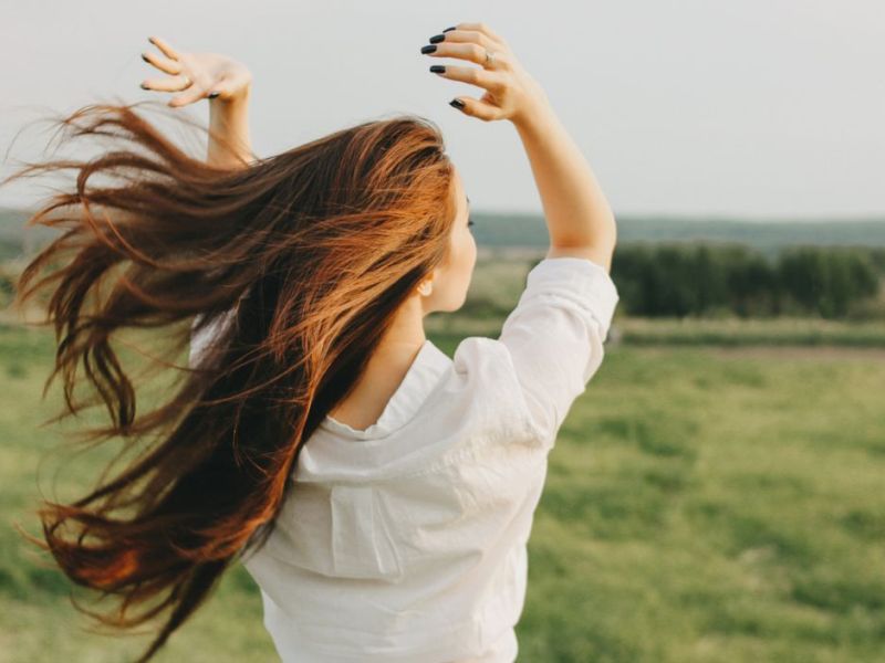 Frau auf einem Feld, mit Wind im Haar 