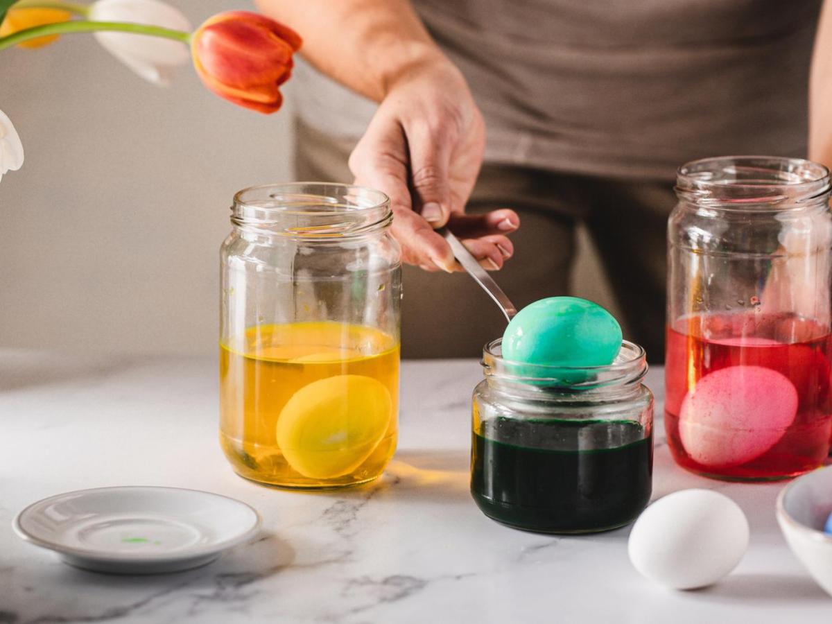 Frau f&auml;rbt Eier in Gl&auml;sern.