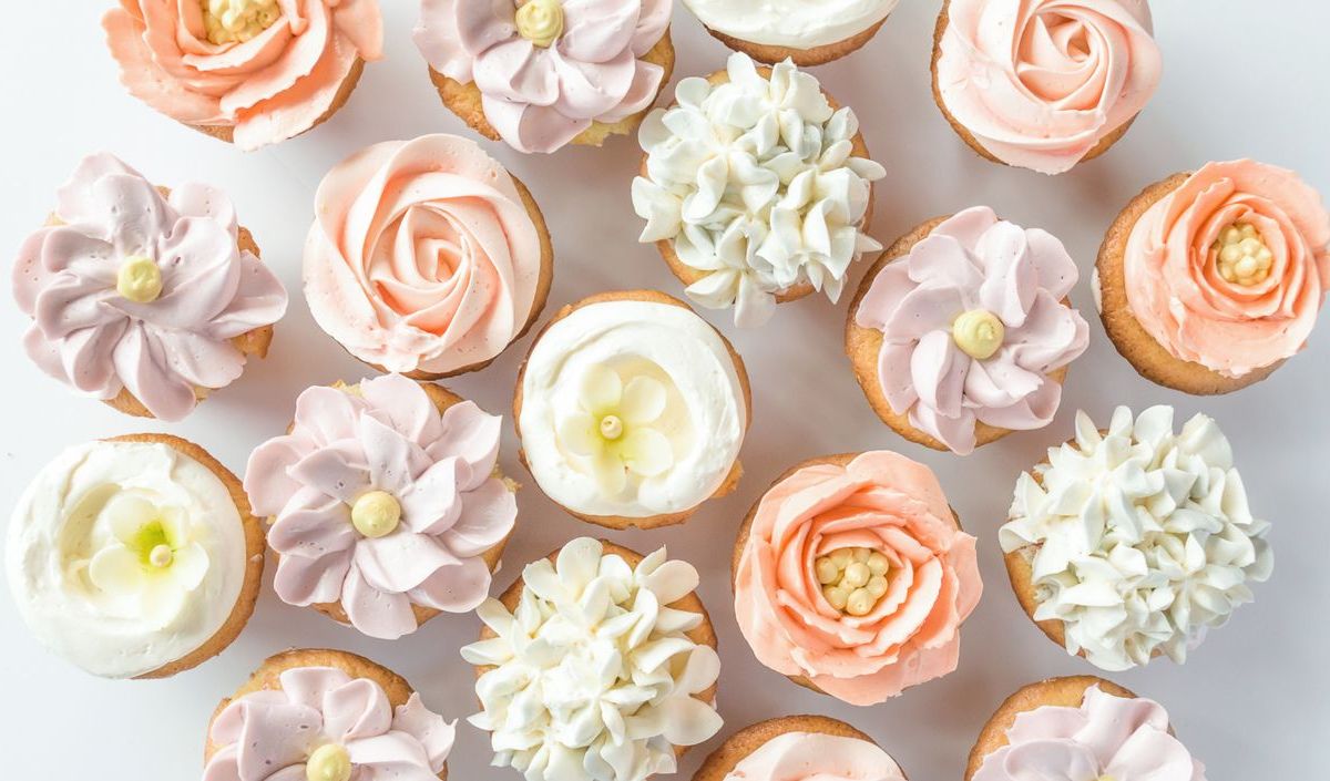 Mehrere Cupcake mit Blumen aus Buttercreme.