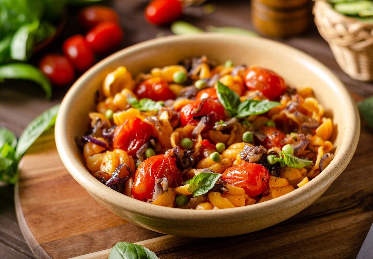 Schüssel mit bunter Gemüsemischung und Pasta.