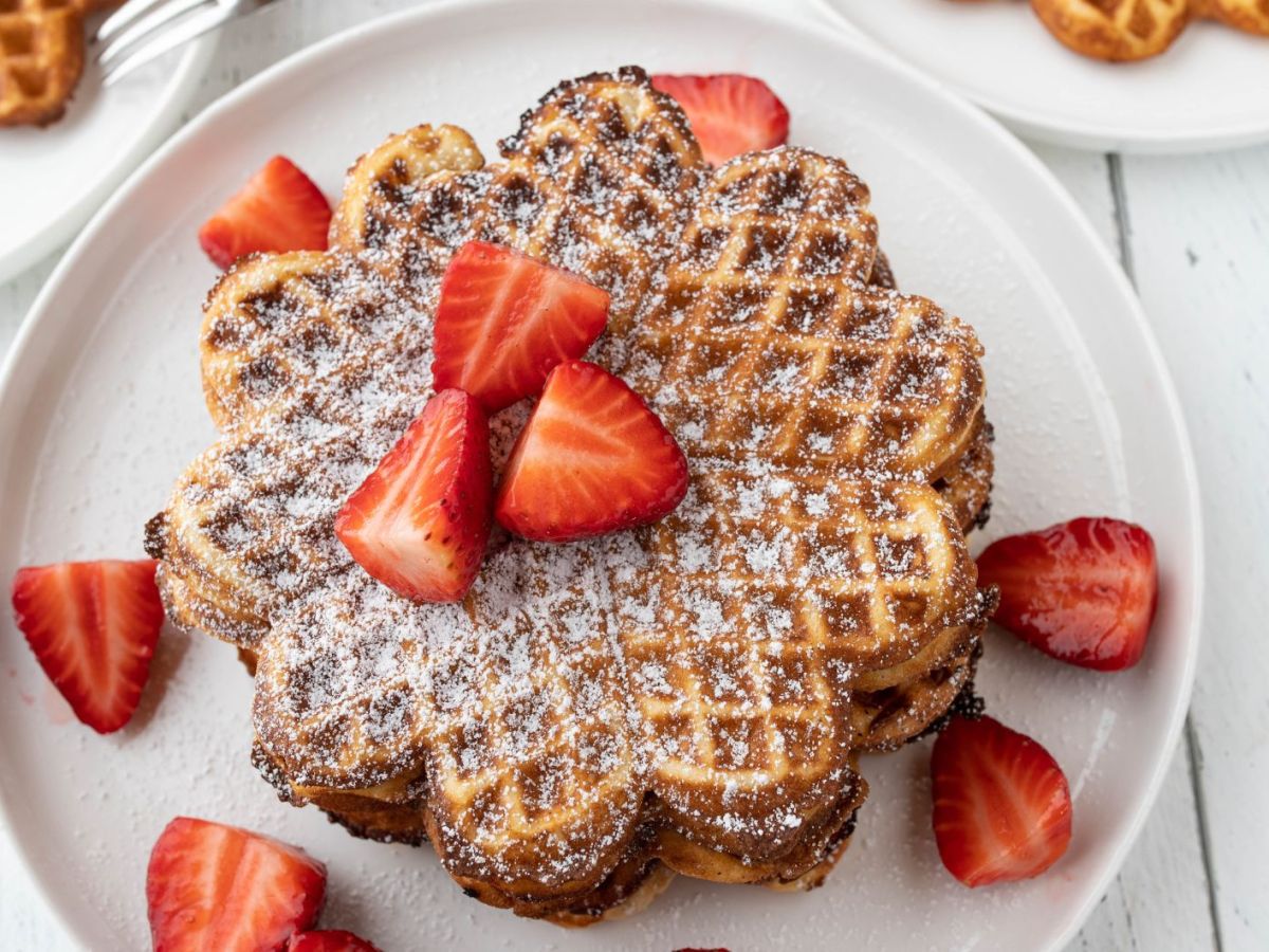 Waffeln mit Erdbeeren auf einem weißen Teller.