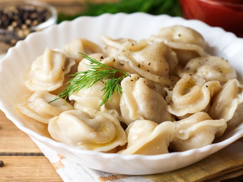 Russische Pelmeni in einer weißen Schüssel.