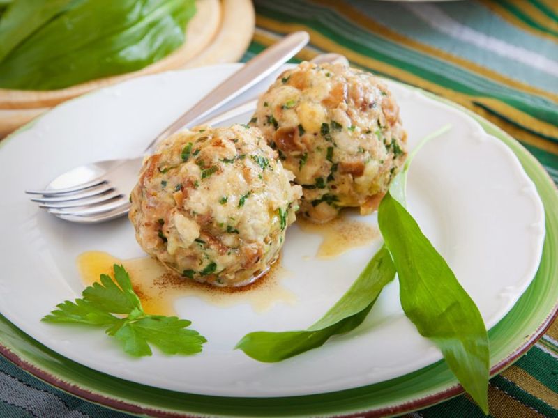 Bärlauchknödel auf einem großen weißen Teller.