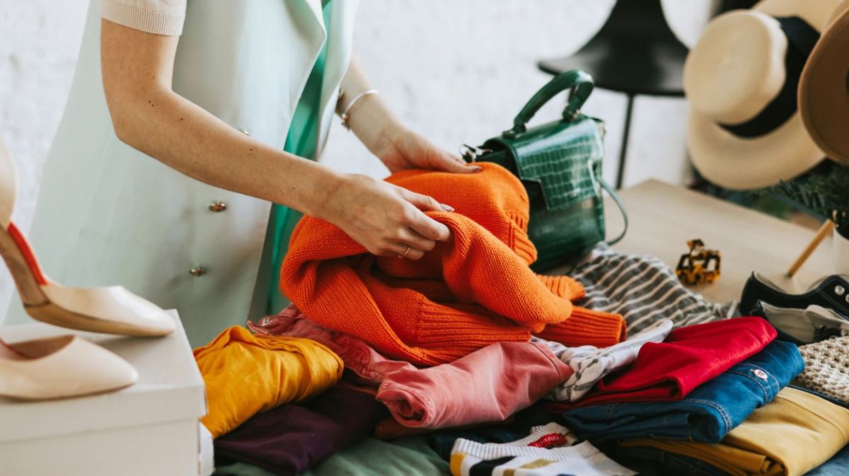 Frau schaut sich Kleidung auf Flohmarkt an