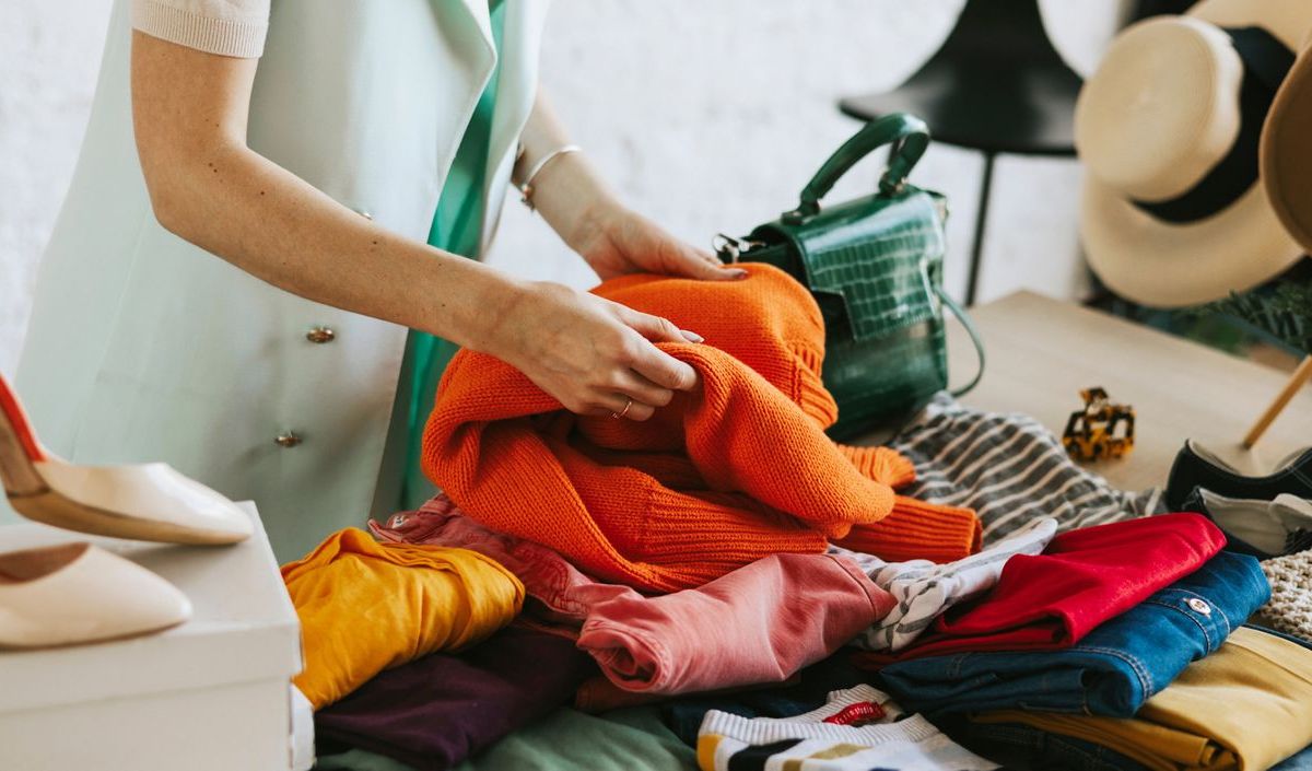 Frau schaut sich Kleidung auf Flohmarkt an