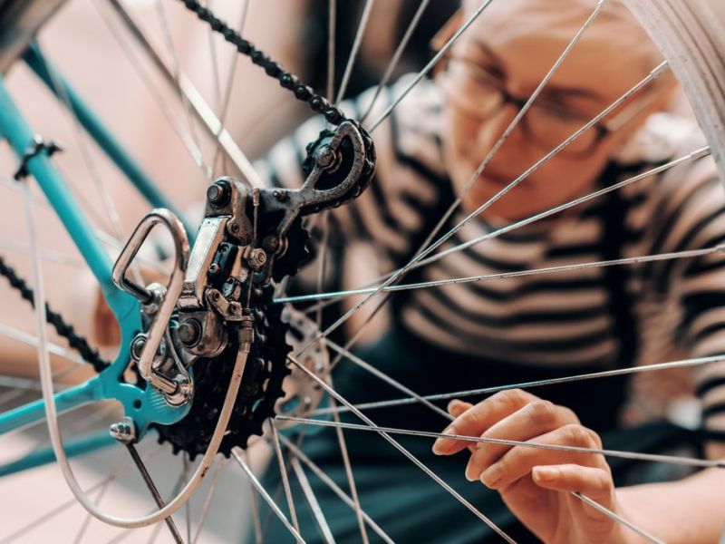 Eine Frau reinigt oder repariert ihr Fahrrad
