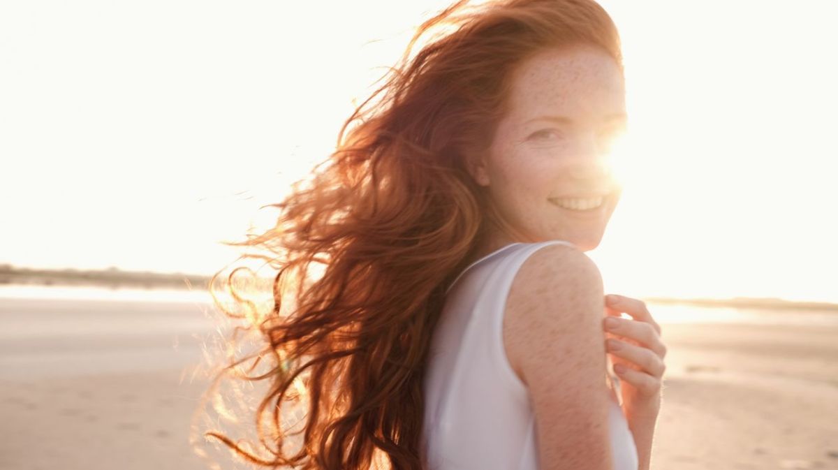 Frau am Strand im Sonnenuntergang am Lächeln 