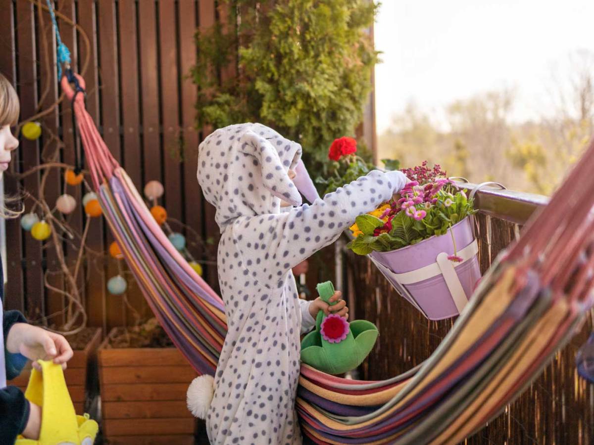 Zwei Kinder, noch in Pyjamas, suchen auf dem Balkon nach Ostereiern.