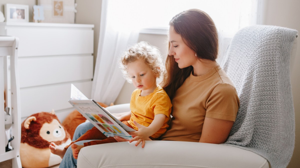 Mama liest Buch mit Baby Junge Kleinkind zu Hause.