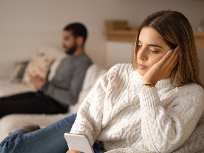 Frau guckt bedrückt ins Smartphone